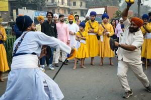 Delhi, India, October 2, 2023 - Sikhs display gatka and martial arts during annual Nagar Kirtan, Traditional, procession on account of birthday of Guru Nanak Dev ji, Nagar Kirtan in East Delhi area photo