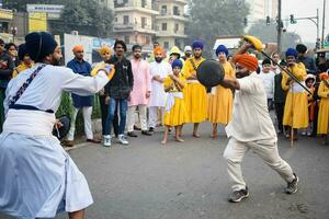 Delhi, India, October 2, 2023 - Sikhs display gatka and martial arts during annual Nagar Kirtan, Traditional, procession on account of birthday of Guru Nanak Dev ji, Nagar Kirtan in East Delhi area photo