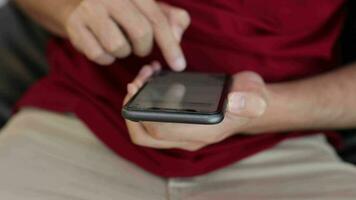 man's hand holding phone in home video