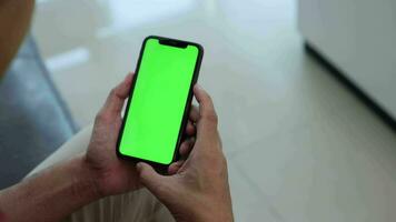 Smartphone Grün Bildschirm im Hand, ein Herren Hand ist halten ein Telefon. video