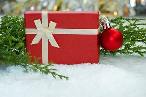 Christmas arrangement with Christmas tree branches, red tinsel, red gift and silver tinsel photo