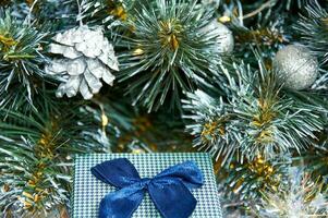 Christmas composition with Christmas tree branches in blue and silver balls and blue gift box photo