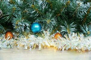 Christmas background with Christmas tree branches, blue and yellow layers and silver tinsel on a wooden background. Copy space for text photo