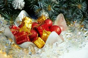 Christmas composition with Christmas tree branches, red balls on yellow gifts in silver tinsel photo