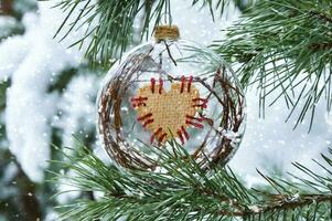 Christmas and New Year holidays background. Christmas decoration close-up on the branches of a snowy spruce in the forest photo