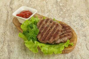 Grilled beef burger cutlet with sauce photo