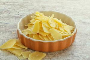 Sliced parmesan cheese heap in the bowl photo