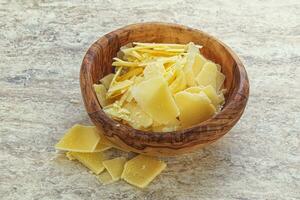 Sliced parmesan cheese heap in the bowl photo