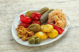 Plate with pickled vegetables and mushrooms photo
