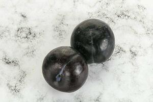 Two ripe sweet black plums photo