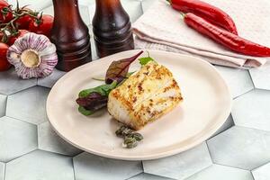 Roasted cod fish steak with salad photo