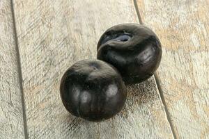 Two ripe sweet black plums photo