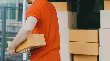 Fast and reliable service. Cheerful young delivery man giving a cardboard box to young woman while standing at the entrance of her apartment video