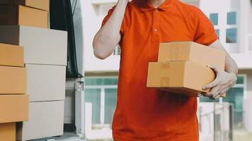 Fast and reliable service. Cheerful young delivery man giving a cardboard box to young woman while standing at the entrance of her apartment video