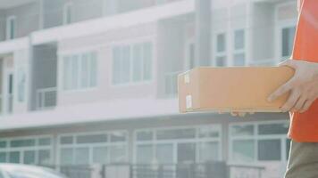 Fast and reliable service. Cheerful young delivery man giving a cardboard box to young woman while standing at the entrance of her apartment video