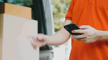 Fast and reliable service. Cheerful young delivery man giving a cardboard box to young woman while standing at the entrance of her apartment video