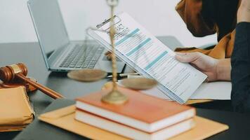 Business and lawyers discussing contract papers with brass scale on desk in office. Law, legal services, advice, justice and law concept picture with film grain effect video