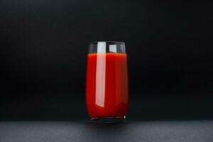 Glass of tomato juice isolated on black background with copy space photo