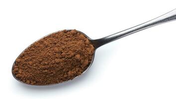 Cocoa powder in spoon isolated on white background. Top view photo