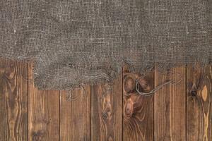 Burlap on wooden table background, top view photo