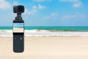 Pocket Handheld Gimbal Action Camera on an Ocean or Sea Summer Beach. 3d Rendering photo