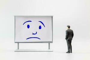 Miniature people, A dejected businessman is positioned in front of a white board, Blue monday concept photo