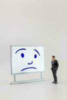 Miniature people, A dejected businessman is positioned in front of a white board, Blue monday concept photo