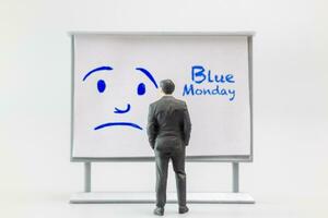 Miniature people, A dejected businessman is positioned in front of a white board, Blue monday concept photo