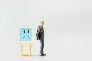 Miniature people, A dejected businessman is positioned in front of a white board, Blue monday concept photo