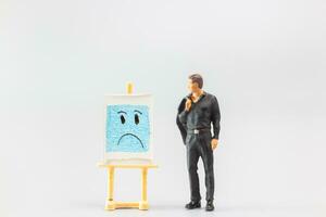Miniature people, A dejected businessman is positioned in front of a white board, Blue monday concept photo