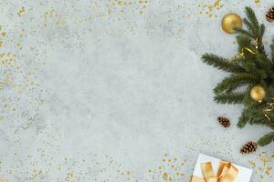 New Year grey concrete background with Christmas tree with golden ball and gifts with free copy space for text and design, concept. Christmas and New Year background card, creative idea photo