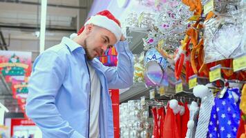 man choose Santa Claus hat in store video