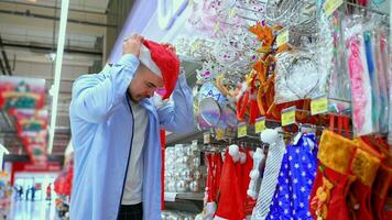 Mens proberen de kerstman claus hoed in winkel video