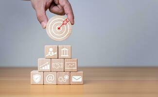 Businessman's hands hold a circular wooden board with printed target icons, business goals and objectives concept, business competition. photo