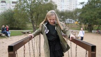 Little happy girls playing on the playground in a summer city park slow motion video