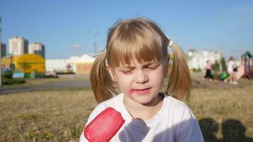 portrait of a little girl in the summer in the park eats ice cream 4k video