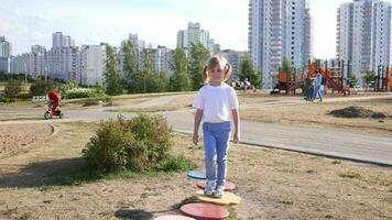 liten flicka barn spelar på de lekplats i de sommar i de parkera video