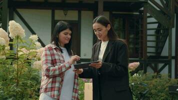 caucasien femme panneaux une numérique Contrat avec un asiatique réel biens agent. video
