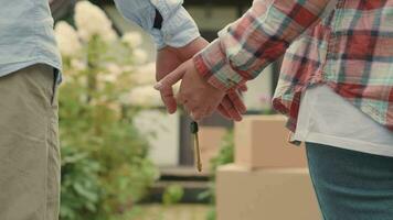 An African man and a Caucasian woman join hands holding the keys to a purchased house. video