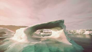 A large iceberg floating in the middle of a body of water video