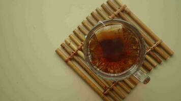 Cup of tea with tea bag on wooden table closeup. video