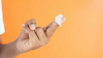 man hand using petroleum jelly against orange color background video
