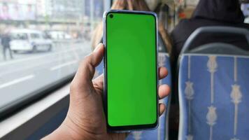 passagerare Sammanträde i en buss använder sig av hans telefon med grön skärm video