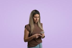 joven adulto mujer participación teléfono inteligente, en pie en estudio con de colores antecedentes foto