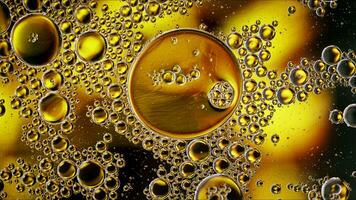 El aceite de comida colorido abstracto cae burbujas y esferas que fluyen en la superficie del agua foto