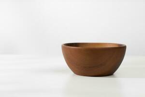 A vacant wooden bowl on the table and a white background in the morning. photo