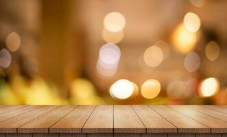 Empty wooden table top with lights bokeh on blur restaurant background. photo