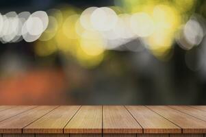 Empty wooden table top with lights bokeh on blur restaurant background. photo