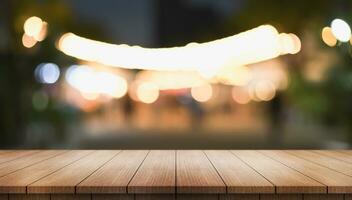 Empty wooden table top with lights bokeh on blur restaurant background. photo