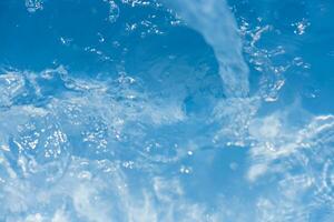 agua Azul burbujas en el superficie ondas desenfocar borroso transparente blanco negro de colores claro calma agua superficie textura con chapoteo y burbujas agua olas con brillante modelo textura antecedentes. foto